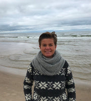 Katrine Hannibal by the sea wearing her "Cloud" super light knitted shawl with lace pattern, made in grey Silk Mohair